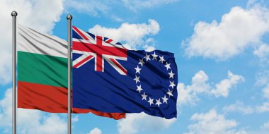 Bulgaristan ve Cook Adaları bayrağı birlikte beyaz bulutlu mavi gökyüzüne karşı rüzgarsal sallayarak. Diplomasi kavramı, uluslararası ilişkiler.