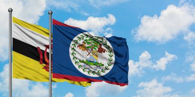Brunei ve Belize bayrağı birlikte beyaz bulutlu mavi gökyüzüne karşı rüzgarda sallayarak. Diplomasi kavramı, uluslararası ilişkiler.