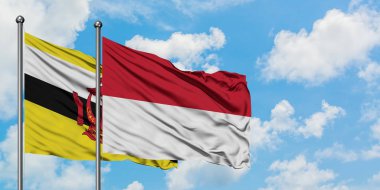Brunei ve Endonezya bayrağı birlikte beyaz bulutlu mavi gökyüzüne karşı rüzgarsal sallayarak. Diplomasi kavramı, uluslararası ilişkiler.