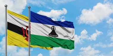 Brunei ve Lesotho bayrağı birlikte beyaz bulutlu mavi gökyüzüne karşı rüzgarda sallayarak. Diplomasi kavramı, uluslararası ilişkiler.