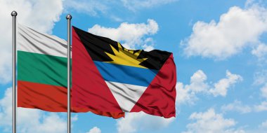 Bulgaristan ve Antigua ve Barbuda bayrağı birlikte beyaz bulutlu mavi gökyüzüne karşı rüzgarda sallayarak. Diplomasi kavramı, uluslararası ilişkiler.