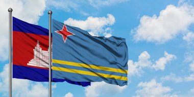 Kamboçya ve Aruba bayrağı birlikte beyaz bulutlu mavi gökyüzüne karşı rüzgarda sallayarak. Diplomasi kavramı, uluslararası ilişkiler.