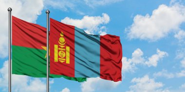 Burkina Faso ve Moğolistan bayrağı birlikte beyaz bulutlu mavi gökyüzüne karşı rüzgarda sallayarak. Diplomasi kavramı, uluslararası ilişkiler.