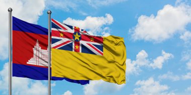 Kamboçya ve Niue bayrağı birlikte beyaz bulutlu mavi gökyüzüne karşı rüzgarda sallayarak. Diplomasi kavramı, uluslararası ilişkiler.