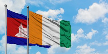 Kamboçya ve Fildişi Sahili bayrağı birlikte beyaz bulutlu mavi gökyüzüne karşı rüzgarda sallayarak. Diplomasi kavramı, uluslararası ilişkiler.