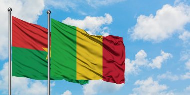 Burkina Faso ve Mali bayrağı birlikte beyaz bulutlu mavi gökyüzüne karşı rüzgarda sallayarak. Diplomasi kavramı, uluslararası ilişkiler.