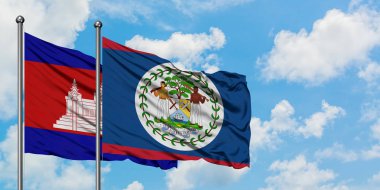 Kamboçya ve Belize bayrağı birlikte beyaz bulutlu mavi gökyüzüne karşı rüzgarda sallayarak. Diplomasi kavramı, uluslararası ilişkiler.