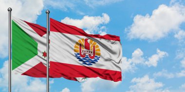 Burundi ve Fransız Polinezyası bayrağı birlikte beyaz bulutlu mavi gökyüzüne karşı rüzgarda sallayarak. Diplomasi kavramı, uluslararası ilişkiler.