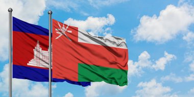 Kamboçya ve Umman bayrağı birlikte beyaz bulutlu mavi gökyüzüne karşı rüzgarda sallayarak. Diplomasi kavramı, uluslararası ilişkiler.