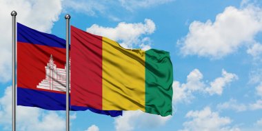 Kamboçya ve Gine bayrağı birlikte beyaz bulutlu mavi gökyüzüne karşı rüzgarda sallayarak. Diplomasi kavramı, uluslararası ilişkiler.