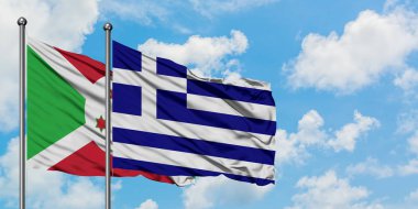 Burundi ve Yunanistan bayrağı birlikte beyaz bulutlu mavi gökyüzüne karşı rüzgarda sallayarak. Diplomasi kavramı, uluslararası ilişkiler.