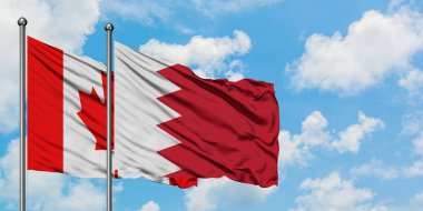 Kanada ve Bahreyn bayrağı birlikte beyaz bulutlu mavi gökyüzüne karşı rüzgarda sallayarak. Diplomasi kavramı, uluslararası ilişkiler.