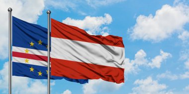 Cape Verde ve Avusturya bayrağı birlikte beyaz bulutlu mavi gökyüzüne karşı rüzgarda sallayarak. Diplomasi kavramı, uluslararası ilişkiler.