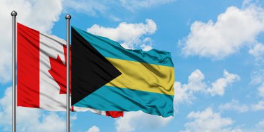 Kanada ve Bahamalar bayrağı birlikte beyaz bulutlu mavi gökyüzüne karşı rüzgarda sallayarak. Diplomasi kavramı, uluslararası ilişkiler.