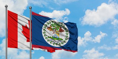 Kanada ve Belize bayrağı birlikte beyaz bulutlu mavi gökyüzüne karşı rüzgarda sallayarak. Diplomasi kavramı, uluslararası ilişkiler.