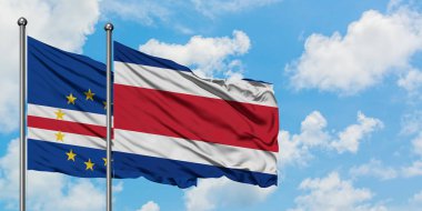 Cape Verde ve Kosta Rika bayrağı birlikte beyaz bulutlu mavi gökyüzüne karşı rüzgarda sallayarak. Diplomasi kavramı, uluslararası ilişkiler.