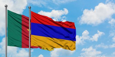 Kamerun ve Ermenistan bayrağı birlikte beyaz bulutlu mavi gökyüzüne karşı rüzgarsal sallayarak. Diplomasi kavramı, uluslararası ilişkiler.