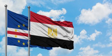 Cape Verde ve Mısır bayrağı birlikte beyaz bulutlu mavi gökyüzüne karşı rüzgarda sallayarak. Diplomasi kavramı, uluslararası ilişkiler.