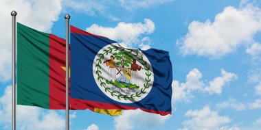 Kamerun ve Belize bayrağı birlikte beyaz bulutlu mavi gökyüzüne karşı rüzgarda sallayarak. Diplomasi kavramı, uluslararası ilişkiler.