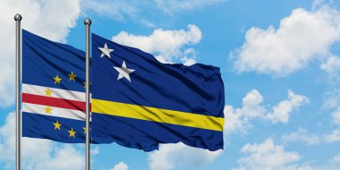 Cape Verde ve Curacao bayrağı birlikte beyaz bulutlu mavi gökyüzüne karşı rüzgarda sallayarak. Diplomasi kavramı, uluslararası ilişkiler.