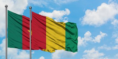 Kamerun ve Gine bayrağı birlikte beyaz bulutlu mavi gökyüzüne karşı rüzgarda sallayarak. Diplomasi kavramı, uluslararası ilişkiler.