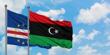 Cape Verde ve Libya bayrağı birlikte beyaz bulutlu mavi gökyüzüne karşı rüzgarda sallayarak. Diplomasi kavramı, uluslararası ilişkiler.
