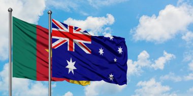 Kamerun ve Avustralya bayrağı birlikte beyaz bulutlu mavi gökyüzüne karşı rüzgarda sallayarak. Diplomasi kavramı, uluslararası ilişkiler.