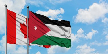 Kanada ve Ürdün bayrağı birlikte beyaz bulutlu mavi gökyüzüne karşı rüzgarda sallayarak. Diplomasi kavramı, uluslararası ilişkiler.