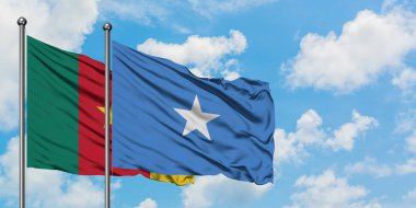 Kamerun ve Somali bayrağı birlikte beyaz bulutlu mavi gökyüzüne karşı rüzgarsal sallayarak. Diplomasi kavramı, uluslararası ilişkiler.