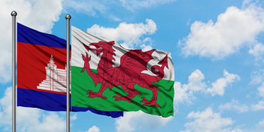 Kamboçya ve Galler bayrağı birlikte beyaz bulutlu mavi gökyüzüne karşı rüzgarda sallayarak. Diplomasi kavramı, uluslararası ilişkiler.