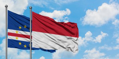 Cape Verde ve Monako bayrağı birlikte beyaz bulutlu mavi gökyüzüne karşı rüzgarda sallayarak. Diplomasi kavramı, uluslararası ilişkiler.