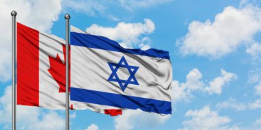 Kanada ve İsrail bayrağı birlikte beyaz bulutlu mavi gökyüzüne karşı rüzgarda sallayarak. Diplomasi kavramı, uluslararası ilişkiler.