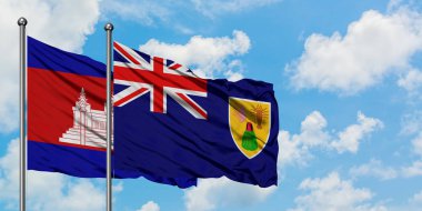 Kamboçya ve Turks ve Caicos Adaları bayrağı birlikte beyaz bulutlu mavi gökyüzüne karşı rüzgarsal sallayarak. Diplomasi kavramı, uluslararası ilişkiler.