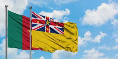 Kamerun ve Niue bayrağı birlikte beyaz bulutlu mavi gökyüzüne karşı rüzgarda sallayarak. Diplomasi kavramı, uluslararası ilişkiler.