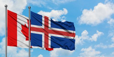 Kanada ve İzlanda bayrağı birlikte beyaz bulutlu mavi gökyüzüne karşı rüzgarda sallayarak. Diplomasi kavramı, uluslararası ilişkiler.