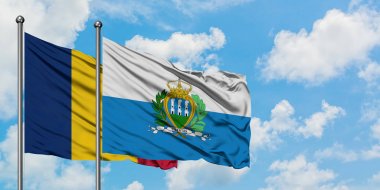 Çad ve San Marino bayrağı birlikte beyaz bulutlu mavi gökyüzüne karşı rüzgarda sallayarak. Diplomasi kavramı, uluslararası ilişkiler.