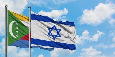 Komorlar ve İsrail bayrağı birlikte beyaz bulutlu mavi gökyüzüne karşı rüzgarda sallayarak. Diplomasi kavramı, uluslararası ilişkiler.