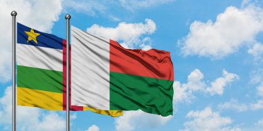 Orta Afrika Cumhuriyeti ve Madagaskar bayrağı birlikte beyaz bulutlu mavi gökyüzüne karşı rüzgarda sallayarak. Diplomasi kavramı, uluslararası ilişkiler.