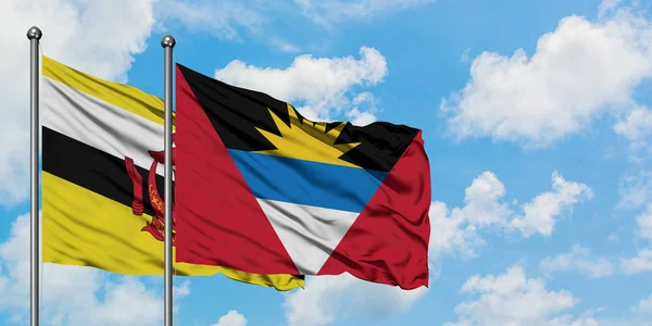 Brunei ve Antigua ve Barbuda bayrağı birlikte beyaz bulutlu mavi gökyüzüne karşı rüzgarda sallayarak. Diplomasi kavramı, uluslararası ilişkiler. — Stok fotoğraf