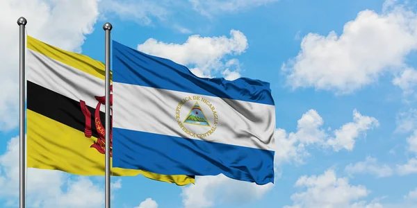 Brunei ve Nikaragua bayrağı birlikte beyaz bulutlu mavi gökyüzüne karşı rüzgarda sallayarak. Diplomasi kavramı, uluslararası ilişkiler. — Stok fotoğraf