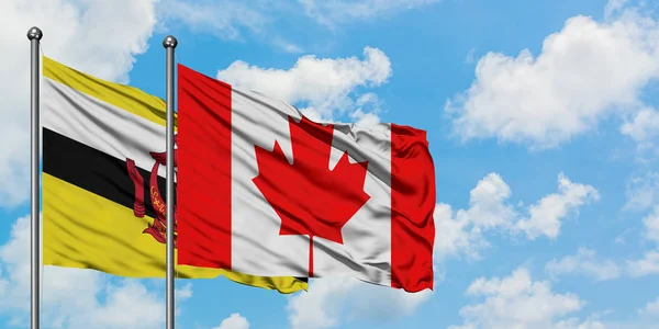 Bandera de Brunéi y Canadá ondeando en el viento contra el cielo azul nublado blanco juntos. Concepto diplomático, relaciones internacionales . — Foto de Stock