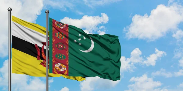 Bandera de Brunei y Turkmenistán ondeando en el viento contra el cielo azul nublado blanco juntos. Concepto diplomático, relaciones internacionales . — Foto de Stock