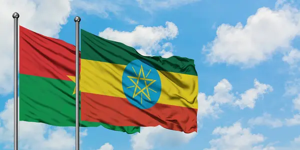 Burkina Faso and Ethiopia flag waving in the wind against white cloudy blue sky together. Diplomacy concept, international relations. — Stock Photo, Image