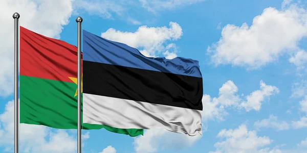 Bandera de Burkina Faso y Estonia ondeando en el viento contra el cielo azul nublado blanco juntos. Concepto diplomático, relaciones internacionales . — Foto de Stock