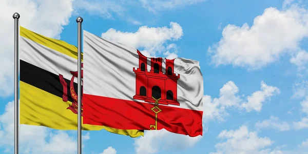 文莱和直布罗陀国旗在风中飘扬，与白云蓝天相一起。外交概念、国际关系. — 图库照片