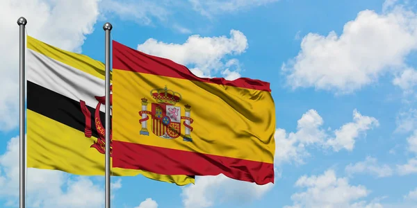 Brunei and Spain flag waving in the wind against white cloudy blue sky together. Diplomacy concept, international relations. — Stock Photo, Image