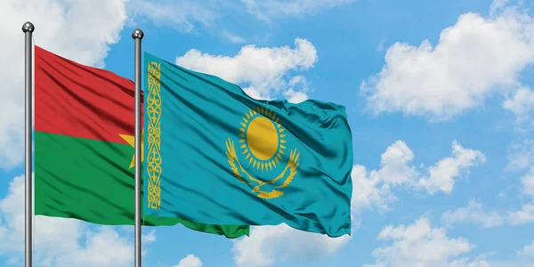 Буркина-Фасо и казахстанский флаг вместе машут ветром против белого облачно-голубого неба. Концепция дипломатии, международные отношения . — стоковое фото