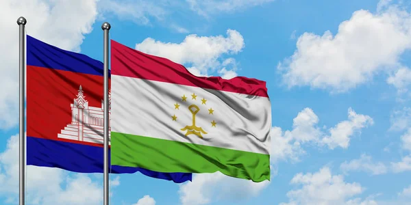 Bandera de Camboya y Tayikistán ondeando en el viento contra el cielo azul nublado blanco juntos. Concepto diplomático, relaciones internacionales . — Foto de Stock