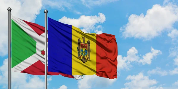 Burundi en Moldavië vlag zwaaien in de wind tegen witte bewolkte blauwe hemel samen. Diplomatie concept, internationale betrekkingen. — Stockfoto