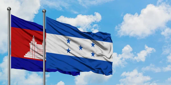Камбоджа і Гондурас прапор розмахував вітром проти білого хмарного синього неба разом. Концепція дипломатії, міжнародні відносини. — стокове фото